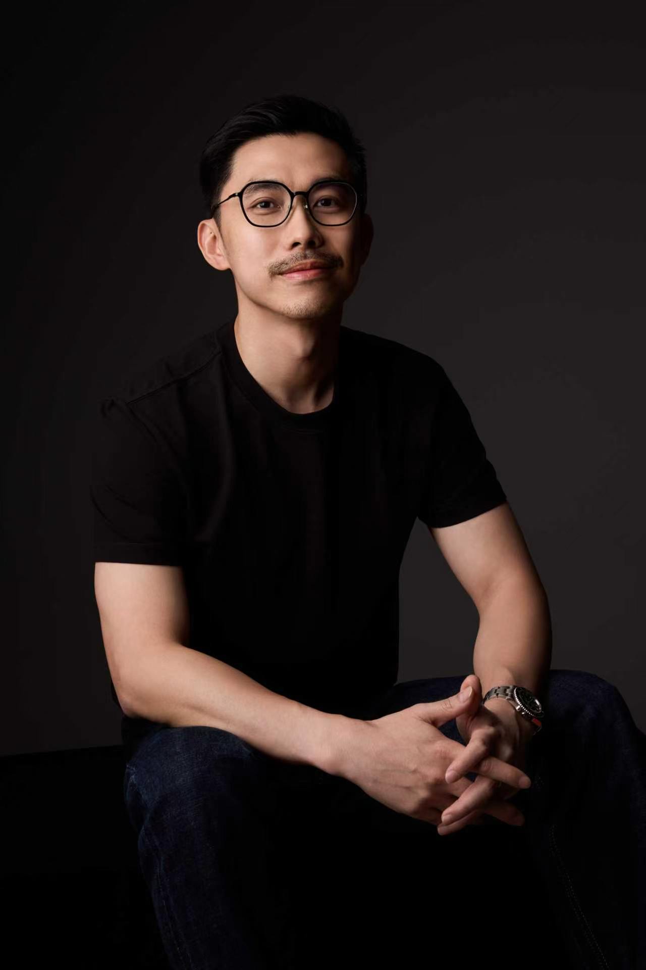 Nate Ong seated in a black T-shirt and glasses.